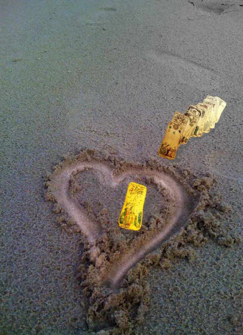 Illustration de la voyance et l’amour : un cœur dans le sable avec une carte de Tarot